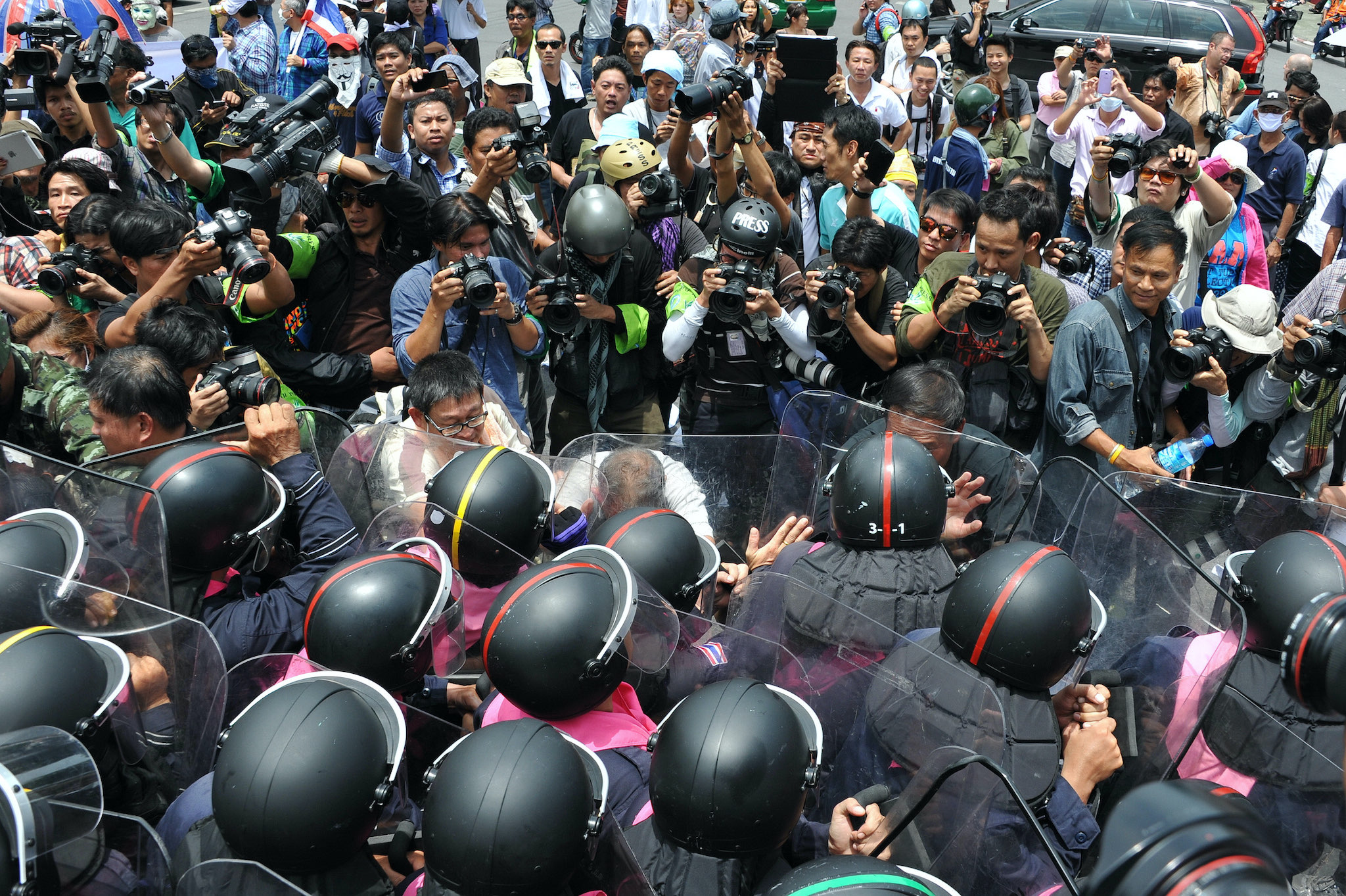 Protesters confront riot police at a barricade near parliament during an anti-amnesty bill rally. Bangkok, Thailand, 07/08/2013. Around 2,500 protesters rallied in opposition to a controversial amnesty bill.